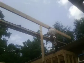 Carpenter setting a ridge beam over a new addition frame — Ice Dam Removal by Roofing Brothers in Parshall