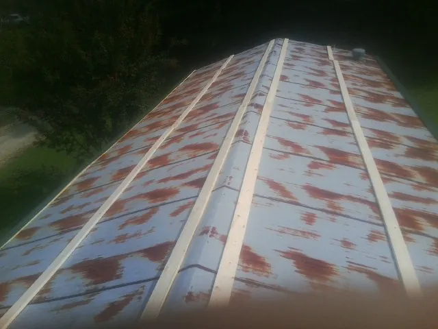 Rusted metal roof panels with new wood purlins before replacement — Storm Damage Roof Repair in Parshall by Roofing Brothers